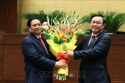 Chủ tịch Quốc hội Vương Đình Huệ tặng hoa chúc mừng Thủ tướng Phạm Minh Chính. Ảnh: Dương Giang - TTXVN