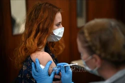 Nhân viên y tế tiêm vaccine phòng COVID-19 cho người dân tại London, Anh, ngày 4/12/2021. Ảnh: AFP/ TTXVN