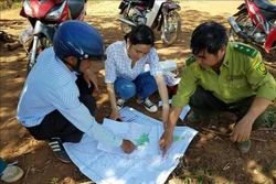 Cán bộ Quỹ Bảo vệ và Phát triển rừng tỉnh Kon Tum kiểm tra thực tế diện tích rừng giao cho người dân quản lý, bảo vệ. Ảnh: TTXVN phát.