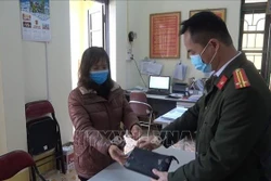 Chị Hoàng Hồng Lĩnh trao số tiền nhặt được cho Công an phường Tân Giang, (thành phố Cao Bằng, tỉnh Cao Bằng), đề nghị Công an phường tìm kiếm, xác minh, trao trả số tiền cho người mất. Ảnh: TTXVN