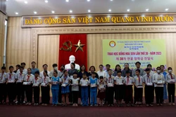 Các thành viên Làng Hoa Sen quốc tế Hàn Quốc trao học bổng cho học sinh. Ảnh: Trịnh Bang Nhiệm - TTXVN