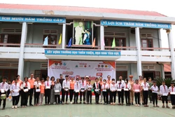 Ban tổ chức trao tặng học bổng cho học sinh có hoàn cảnh khó khăn vượt khó vươn lên trong học tập. Ảnh: Tuấn Anh – TTXVN