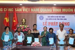 Trao thẻ bảo hiểm y tế cho người dân có hoàn cảnh khó khăn. Ảnh: Lê Thúy Hằng - TTXVN