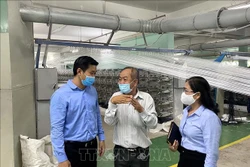 Ông Hứa Quốc Hưng, Trưởng Ban Quản lý các Khu chế xuất, Khu công nghiệp Thành phố Hồ Chí Minh cùng đoàn đại biểu với lãnh đạo Công ty trách nhiệm hữu hạn In và sản xuất bao bì Đức Mỹ, ở khu công nghiệp Hiệp Phước. Ảnh: Thanh Vũ - TTXVN