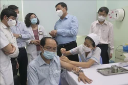 Thứ trưởng Bộ Y tế Đỗ Xuân Tuyên kiểm tra việc triển khai tiêm vaccine tại Bệnh viện Đa khoa Hùng Vương (Quận 5). Ảnh: Thu Hương - TTXVN