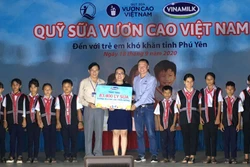 Đại diện Sở Lao động, Thương binh và Xã hội tỉnh Phú Yên, Công ty Cổ phần sữa Việt Nam (Vinamilk) trao bảng tượng trưng 83.400 li sữa cho trẻ em nghèo tỉnh Phú Yên. Ảnh: Phạm Cường-TTXVN