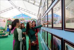 Khách tham quan Triển lãm ảnh “Du lịch văn hóa, lịch sử và sinh thái vùng Việt Bắc”. Ảnh: Thu Hằng-TTXVN