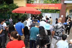 14h chiều 6/11, tại điểm tiêm phòng COVID-19 phường Kim Liên, quận Đống Đa, người dân chen chúc đến xếp hàng tiêm phòng không đảm bảo giữ khoảng cách. Ảnh: Thành Đạt - TTXVN