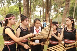 Các cô gái Bahnar đang chỉ dạy cách chơi đàn T'rưng cho các em học sinh. Ảnh: Quang Thái - TTXVN