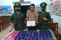 Đối tượng Tòng Văn Hinh cùng tang vật. Ảnh: Nguyễn Cường - TTXVN phát.