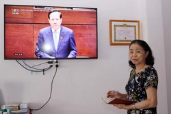 Cử tri là đảng viên Lê Thị Đào Liễu (quận Hải Châu, thành phố Đà Nẵng) theo dõi phiên chất vấn và trả lời chất vấn tại Kỳ họp thứ 5, Quốc hội khóa XV vào chiều 6/6. Ảnh: Trần Lê Lâm - TTXVN