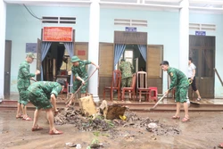 Lực lượng biên phòng cùng với cán bộ phường Ghềnh Ráng (Quy Nhơn) dọn dẹp bùn non tại trụ sở làm việc. Ảnh: Sỹ Thắng - TTXVN