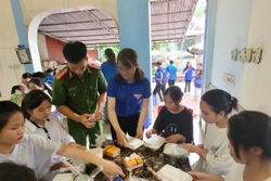 Những phần cơm nóng hổi được trao tận tay các thí sinh lúc rời phòng thi. Ảnh: Vũ Hoàng Giang - TTXVN