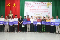 Trao bảng tượng trưng bàn giao nhà đại đoàn kết cho hộ nghèo. Ảnh: Thanh Hòa - TTXVN
