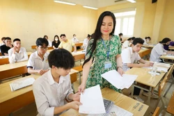 Giám thị phát giấy nháp cho thí sinh tại điểm thi Trường THPT Đoàn Kết - Hai Bà Trưng trong kỳ thi tốt nghiệp THPT năm 2023. Ảnh: Thanh Tùng - TTXVN