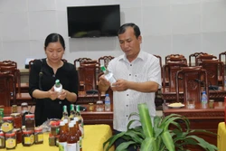 Ông Trần Hoàng Nhật Nam, Phó Giám đốc Sở Nông nghiệp và Phát triển nông thôn, Phó Chủ tịch Hội đồng đánh giá, phân hạng sản phẩm OCOP tỉnh Tiền Giang, xem xét sản phẩm trước khi đánh giá. Ảnh: Minh Trí - TTXVN