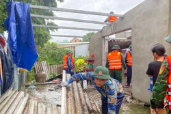 Bộ đội Biên phòng tỉnh Thừa Thiên - Huế phối hợp với chính quyền địa phương hỗ trợ các gia đình bị thiệt hại lợp lại, gia cố mái nhà. Ảnh: TTXVN phát