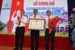 Lãnh đạo tỉnh Hậu Giang trao bảng công nhận xã Đại Thành, thành phố Ngã Bảy đạt chuẩn nông thôn mới kiểu mẫu. Ảnh: Nguyễn Hằng - TTXVN