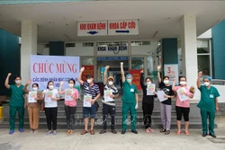 Đại diện Bệnh viện dã chiến Hòa Vang trao giấy xuất viện cho các bệnh nhân. Ảnh: Văn Dũng - TTXVN