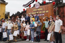 Chính quyền thành phố Hội An tặng quà lưu niệm cho các đoàn khách quốc tế đầu tiên đến tham quan phố cổ Hội An vào ngày 20/11 theo chương trình du lịch "Hộ chiếu vaccine" sau 2 năm bị gián đoạn do đại dịch COVID-19. Ảnh: Đoàn Hữu Trung - TTXVN