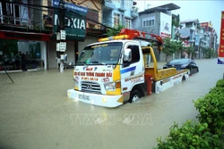Xe cứu hộ giao thông kéo một phương tiện bị chết máy do ngập nước. Ảnh: Phan Tuấn Anh - TTXVN