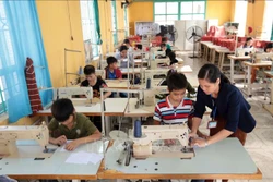 Dạy nghề may công nghiệp cho học sinh tại trường Phục hồi chức năng và dạy nghề cho người khuyết tật huyện Khoái Châu. Ảnh: Phạm Kiên - TTXVN