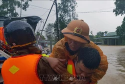 Di chuyển người dân ra khỏi khu vực ngập lũ tại huyện Cam Lộ. Ảnh: Thanh Thủy-TTXVN