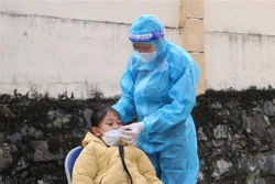 Y sỹ Nguyễn Thị Hạnh, Trạm y tế phường Đông Phong mỗi ngày test nhanh cho gần 100 người dân. Ảnh: Đinh Thùy-TTXVN 