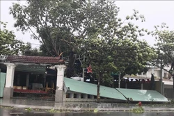 Nhiều hàng quán, bảng hiệu bị tốc mái, đổ ngổn ngang. Ảnh: Phạm Kha - TTXVN