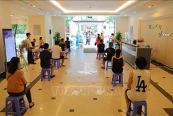 Cư dân ngồi giãn cách đợi lấy mẫu xét nghiệm SARS-CoV-2 trong sáng 11/8. Ảnh: Thanh Tùng - TTXVN 