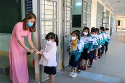  Xịt nước rửa tay kháng khuẩn cho học sinh trước khi vào lớp. Ảnh: Hồng Điệp - TTXVN 