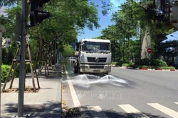Công ty TNHH MTV Môi trường Đô thị Hà Nội, thực hiện tưới nước làm mát, giảm bụi trong những ngày nắng nóng. Ảnh Minh Nghĩa/TTXVN