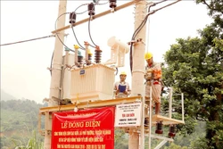 Cán bộ kỹ thuật của điện lực Thái Nguyên đóng điện cho công trình điện xóm Cao Biền. Ảnh: Hoàng Nguyên - TTXVN 