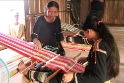 Bà H’Yam (trái), Giám đốc Hợp tác xã Dệt thổ cẩm Tơng Bông hướng dẫn xã viên dệt thổ cẩm. Ảnh: TTXVN phát