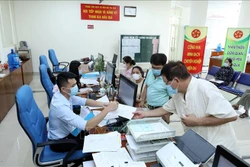 Hướng dẫn người dân khai hồ sơ tại Trung tâm Phục vụ hành chính công tỉnh Lạng Sơn. Ảnh: Anh Tuấn - TTXVN 
