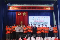 Đại diện Hội Chữ thập đỏ tỉnh Khánh Hòa trao áo phao cứu sinh đa năng cho ngư dân huyện Vạn Ninh, tỉnh Khánh Hòa. Ảnh: Phan Sáu - TTXVN 
