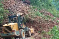 Công ty Cổ phần bảo trì đường bộ 1 Lai Châu, đơn vị quản lý tuyến đường huy động máy xúc san gạt đất đá nhằm thông xe trong ngày 8/8. Ảnh: TTXVN phát 