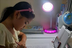 Nhiều gia đình khó khăn trong việc mua máy tính trong khi học sinh học trực tuyến trên điện thoại . Ảnh: TTXVN phát 