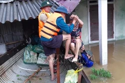Lực lượng chức năng giúp người dân di dời đến nơi an toàn. Ảnh: TTXVN phát