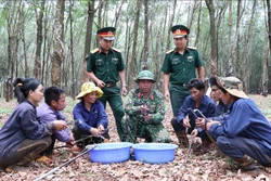 Anh Kpui Sinh, dân tộc Jrai, tổ trưởng Tổ 3, Đội 10, Công ty 74, Binh đoàn 15 (giữa, hàng trước) đảng viên người dân tộc thiểu số hướng dẫn cho công nhân cách mài dao cạo mủ cao su. Ảnh: Hồng Điệp - TTXVN