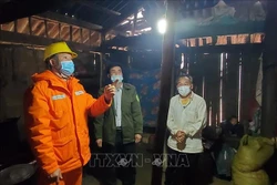 Công nhân Điện lực Mai Sơn, tỉnh Sơn La hướng dẫn người dân xã Chiềng Kheo sử dụng điện an toàn. Ảnh: TTXVN phát 