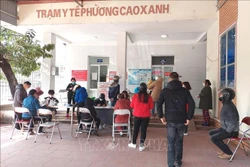Lượng người dân là F1, F0 đến trạm y tế khá đông cùng thời điểm nhưng nhân viên y tế chỉ có 1 người tiếp đón, sàng lọc, hướng dẫn, dẫn đến tình trạng quá tải, không có người để tư vấn. Ảnh: Thanh Vân-TTXVN 