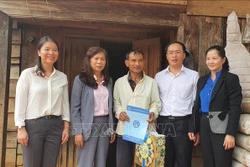 Lãnh đạo Ban Dân vận, Tỉnh ủy Lâm Đồng cũng đến thăm tặng quà và trao tận tay 3 hộ nghèo có hoàn cảnh khó khăn thẻ bảo hiểm y tế. Ảnh: Đặng Tuấn - TTXVN