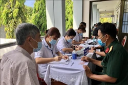 Nhân viên y tế thuộc Trung tâm Y tế Quân dân y huyện Côn Đảo Khám sàng lọc trước khi tiêm vaccine cho các đối tượng ưu tiên. Ảnh: TTXVN