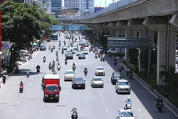 Người dân mặc kín mít khi phải di chuyển trên đường giữa trời nắng nóng. Ảnh: Hoàng Hiếu - TTXVN 