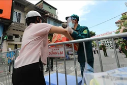 Nhu yếu phẩm được gửi vào cho người thân đang sống trong khu vực phường Văn Miếu, quận Đống Đa bị phong tỏa. Ảnh: Thanh Tùng - TTXVN 