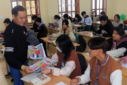 Cán bộ Trung tâm Y tế phát tờ rơi tuyên truyền về sức khỏe sinh sản cho học sinh. Ảnh: Hữu Quyết – TTXVN 