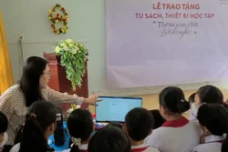 Cô và trò Trường Tiểu học Bình Xuân 1 (thị xã Gò Công) sử dụng máy vi tính vừa được trao tặng từ Chương trình của Agribank Tiền Giang. Ảnh: Hữu Chí – TTXVN 
