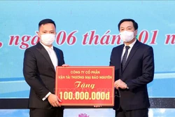 Chủ tịch UBND Thành phố Lạng Sơn Nguyễn Văn Hạnh (bên phải) nhận quà tặng từ các mạnh thường quân. Ảnh: Anh Tuấn – TTXVN 