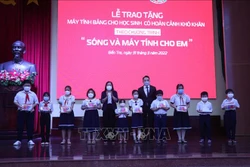 Trao máy tính bảng kèm sim 4G cho học sinh có hoàn cảnh khó khăn. Ảnh: Chương Đài - TTXVN 